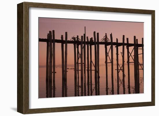 Monk walking at sunrise over the lake near wooden footbridge. Taungthaman Lake, Myanmar.-Michele Niles-Framed Photographic Print