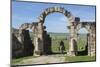 Morocco. A man on a donkey passes under stone columns and arches at the roman ruins of Volubilis.-Brenda Tharp-Mounted Photographic Print