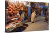 Morocco. An elderly man walks past tourist shops along a street in the blue city of Chefchaouen.-Brenda Tharp-Stretched Canvas