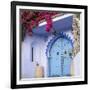 Morocco, Chefchaouen. Bougainvillea Blossoms Frame an Ornate Blue Door-Brenda Tharp-Framed Photographic Print