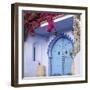 Morocco, Chefchaouen. Bougainvillea Blossoms Frame an Ornate Blue Door-Brenda Tharp-Framed Photographic Print