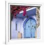 Morocco, Chefchaouen. Bougainvillea Blossoms Frame an Ornate Blue Door-Brenda Tharp-Framed Photographic Print