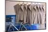 Morocco, Essaouira, Djellabas Hanging on Wall Next to Bicycle-Emily Wilson-Mounted Photographic Print