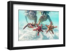 Mother and son with scuba masks showing red starfish underwater, Zanzibar, Tanzania-Roberto Moiola-Framed Photographic Print