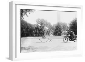 Motorcycle Cop Chases a Penny Farthing Velocipede Down a DC Street with Washington Monument in Back-null-Framed Art Print