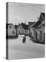 Motorcycle Going Down Street in Small Town-null-Stretched Canvas