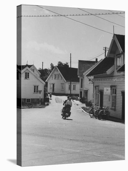 Motorcycle Going Down Street in Small Town-null-Stretched Canvas