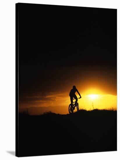 Mountain Biker Against Stormy Sunset, Fruita, Colorado, USA-Chuck Haney-Stretched Canvas