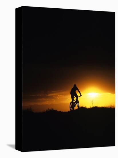 Mountain Biker Against Stormy Sunset, Fruita, Colorado, USA-Chuck Haney-Stretched Canvas