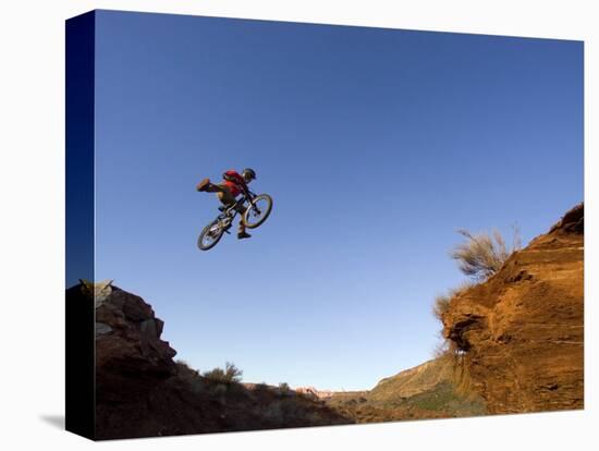 Mountain Biker Catches Air at Rampage Site near Virgin, Utah, USA-Chuck Haney-Stretched Canvas