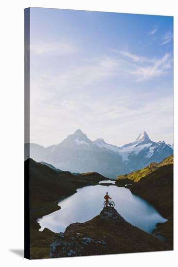 Mountain biker looking at Bachalpsee lake and Bernese Oberland mountains at dawn-Roberto Moiola-Stretched Canvas