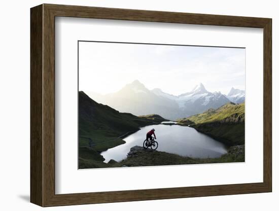 Mountain biker riding downhill at Bachalpsee lake at dawn, Grindelwald, Bernese Oberland-Roberto Moiola-Framed Photographic Print