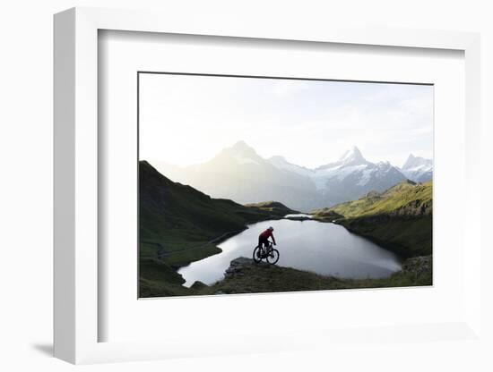 Mountain biker riding downhill at Bachalpsee lake at dawn, Grindelwald, Bernese Oberland-Roberto Moiola-Framed Photographic Print