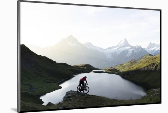 Mountain biker riding downhill at Bachalpsee lake at dawn, Grindelwald, Bernese Oberland-Roberto Moiola-Mounted Photographic Print