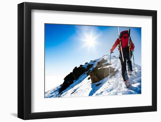 Mountaineer Walking up along a Snowy Ridge with the Skis in the Backpack. in Background a Shiny Bri-Roberto Caucino-Framed Photographic Print