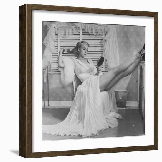 Movie Actress Carole Landis in Negligee as she Brushes Her Hair, Showing Off Gorgeous Legs-Peter Stackpole-Framed Premium Photographic Print