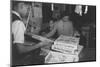 Mrs. Yaeko Nakamura shows her daughters jigsaw puzzles in a store at Manzanar, 1943-Ansel Adams-Mounted Photographic Print