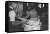 Mrs. Yaeko Nakamura shows her daughters jigsaw puzzles in a store at Manzanar, 1943-Ansel Adams-Framed Stretched Canvas