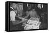 Mrs. Yaeko Nakamura shows her daughters jigsaw puzzles in a store at Manzanar, 1943-Ansel Adams-Framed Stretched Canvas