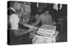 Mrs. Yaeko Nakamura shows her daughters jigsaw puzzles in a store at Manzanar, 1943-Ansel Adams-Stretched Canvas