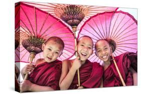 Myanmar, Mandalay Division, Bagan. Portrait of Three Novice Monks under Red Umbrellas (Mr)-Matteo Colombo-Stretched Canvas