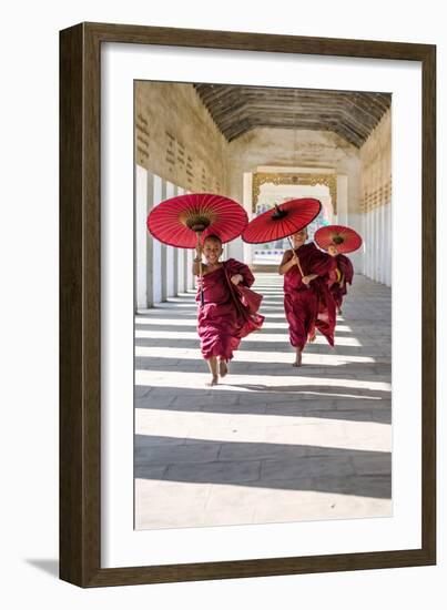 Myanmar, Mandalay Division, Bagan. Three Novice Monks Running with Red Umbrellas in a Walkway (Mr)-Matteo Colombo-Framed Photographic Print