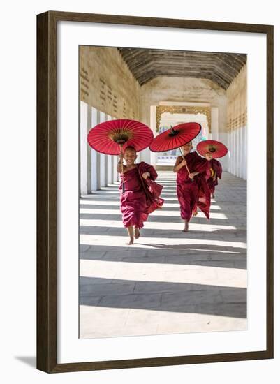 Myanmar, Mandalay Division, Bagan. Three Novice Monks Running with Red Umbrellas in a Walkway (Mr)-Matteo Colombo-Framed Photographic Print