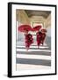 Myanmar, Mandalay Division, Bagan. Three Novice Monks Running with Red Umbrellas in a Walkway (Mr)-Matteo Colombo-Framed Photographic Print