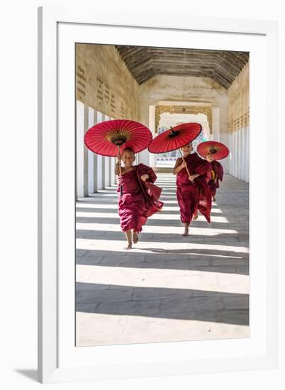 Myanmar, Mandalay Division, Bagan. Three Novice Monks Running with Red Umbrellas in a Walkway (Mr)-Matteo Colombo-Framed Photographic Print