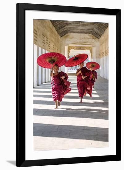 Myanmar, Mandalay Division, Bagan. Three Novice Monks Running with Red Umbrellas in a Walkway (Mr)-Matteo Colombo-Framed Photographic Print