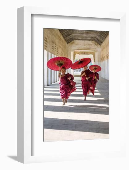 Myanmar, Mandalay Division, Bagan. Three Novice Monks Running with Red Umbrellas in a Walkway (Mr)-Matteo Colombo-Framed Premium Photographic Print