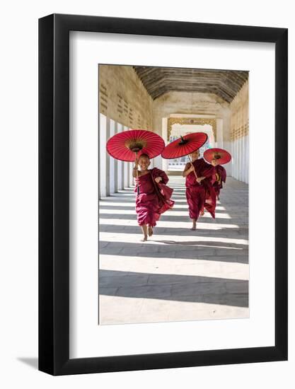 Myanmar, Mandalay Division, Bagan. Three Novice Monks Running with Red Umbrellas in a Walkway (Mr)-Matteo Colombo-Framed Photographic Print