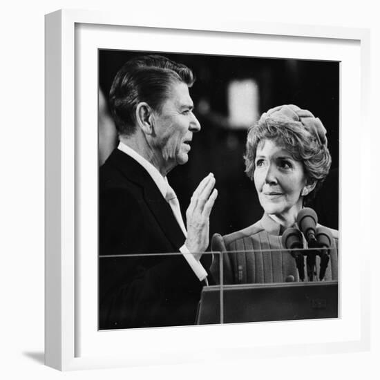 Nancy Reagan Proudly Watches as Her Husband Ronald Reagan Takes the Oath of Office-null-Framed Photographic Print