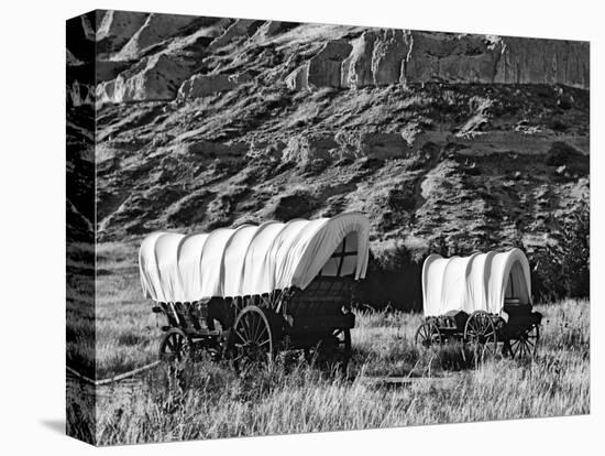 Nebraska, Scotts Bluff National Monument. Covered Wagons in Field-Dennis Flaherty-Stretched Canvas