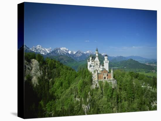 Neuschwanstein Castle on a Wooded Hill with Mountains in the Background, in Bavaria, Germany-null-Stretched Canvas