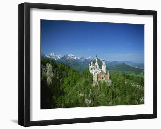 Neuschwanstein Castle on a Wooded Hill with Mountains in the Background, in Bavaria, Germany-null-Framed Photographic Print