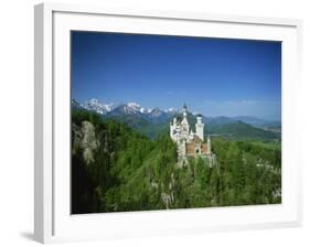 Neuschwanstein Castle on a Wooded Hill with Mountains in the Background, in Bavaria, Germany-null-Framed Photographic Print