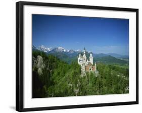 Neuschwanstein Castle on a Wooded Hill with Mountains in the Background, in Bavaria, Germany-null-Framed Photographic Print