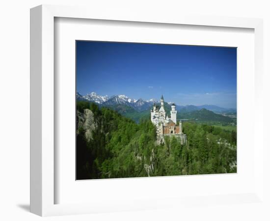 Neuschwanstein Castle on a Wooded Hill with Mountains in the Background, in Bavaria, Germany-null-Framed Photographic Print