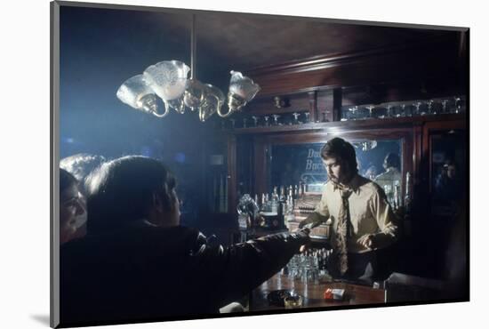 Nhl Boston Bruin Player Derek Sanderson Bartending at His Favorite Boston Bar, 1971-Art Rickerby-Mounted Photographic Print