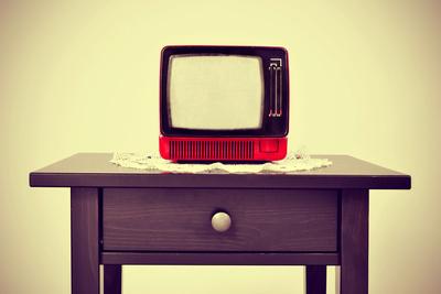 An Ancient Red Television on a Table with a Retro Effect