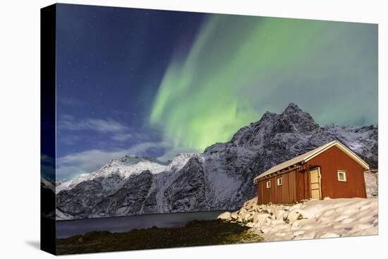 Northern Lights (Aurora Borealis) Illuminate Snowy Peaks and Wooden Cabin on a Starry Night-Roberto Moiola-Stretched Canvas