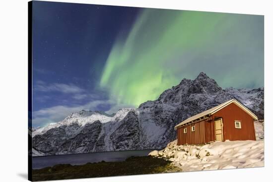 Northern Lights (Aurora Borealis) Illuminate Snowy Peaks and Wooden Cabin on a Starry Night-Roberto Moiola-Stretched Canvas