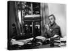 Novelist and Script Writer William Faulkner Smoking a Pipe at His Desk at Warner Brothers Studios-null-Stretched Canvas