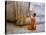 Novice Buddhist Monk Kneeling Beneath the Phra Atchana Buddha Statue, Sukhothai Province, Thailand-Gavin Hellier-Stretched Canvas