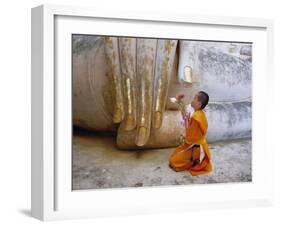 Novice Buddhist Monk Kneeling Beneath the Phra Atchana Buddha Statue, Sukhothai Province, Thailand-Gavin Hellier-Framed Photographic Print