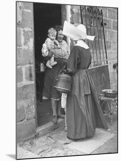 Nun from the Order of Sisters of Charity Visiting a Destitute Family with Supplies-null-Mounted Photographic Print