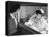 Nurse Aiko Hamaguchi shows new baby to mother in maternity ward, Manzanar War Relocation Center, CA-Ansel Adams-Stretched Canvas