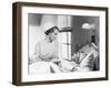 Nurse Comforts a Patient in a Hospital Bed, Talking to Each Other-null-Framed Photo