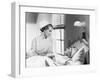 Nurse Comforts a Patient in a Hospital Bed, Talking to Each Other-null-Framed Photo